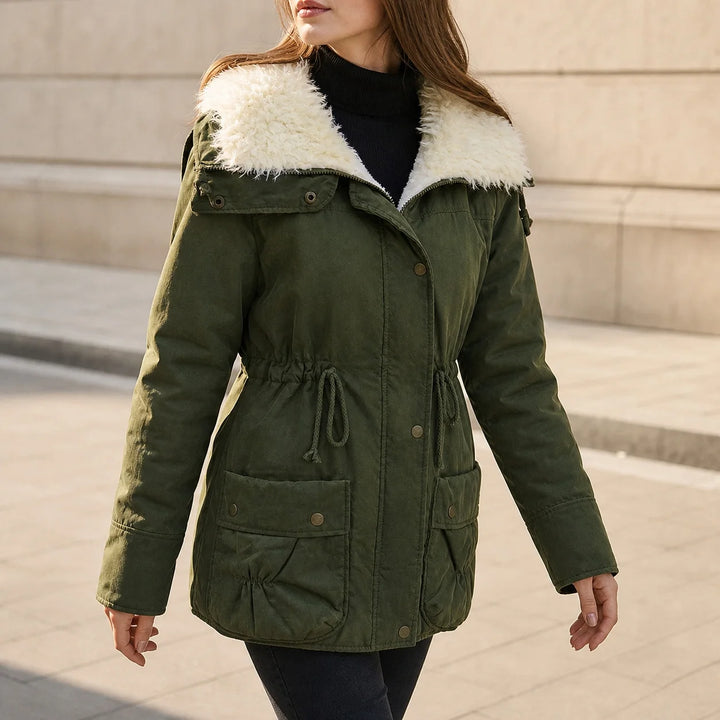 Woman wearing military green hooded parka with faux shearling collar