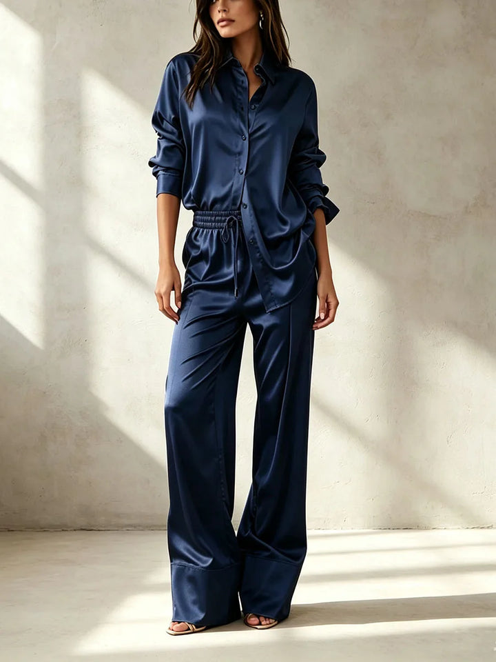 Woman wearing navy blue satin shirt and pant set, front view