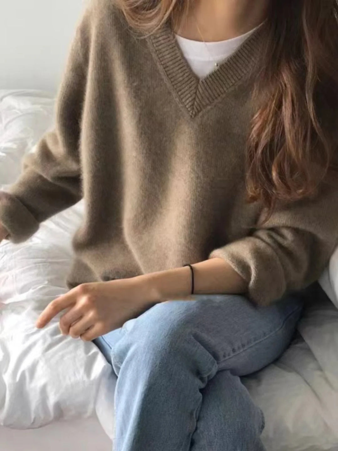 Woman wearing beige V-neck knit sweater
