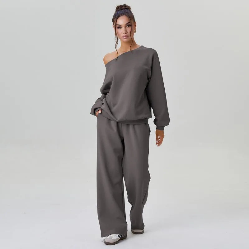 Woman wearing gray off-shoulder tracksuit set with hand in pocket