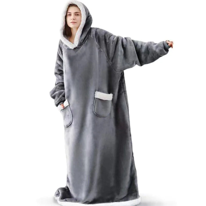 Woman wearing grey hooded wearable blanket with front pockets