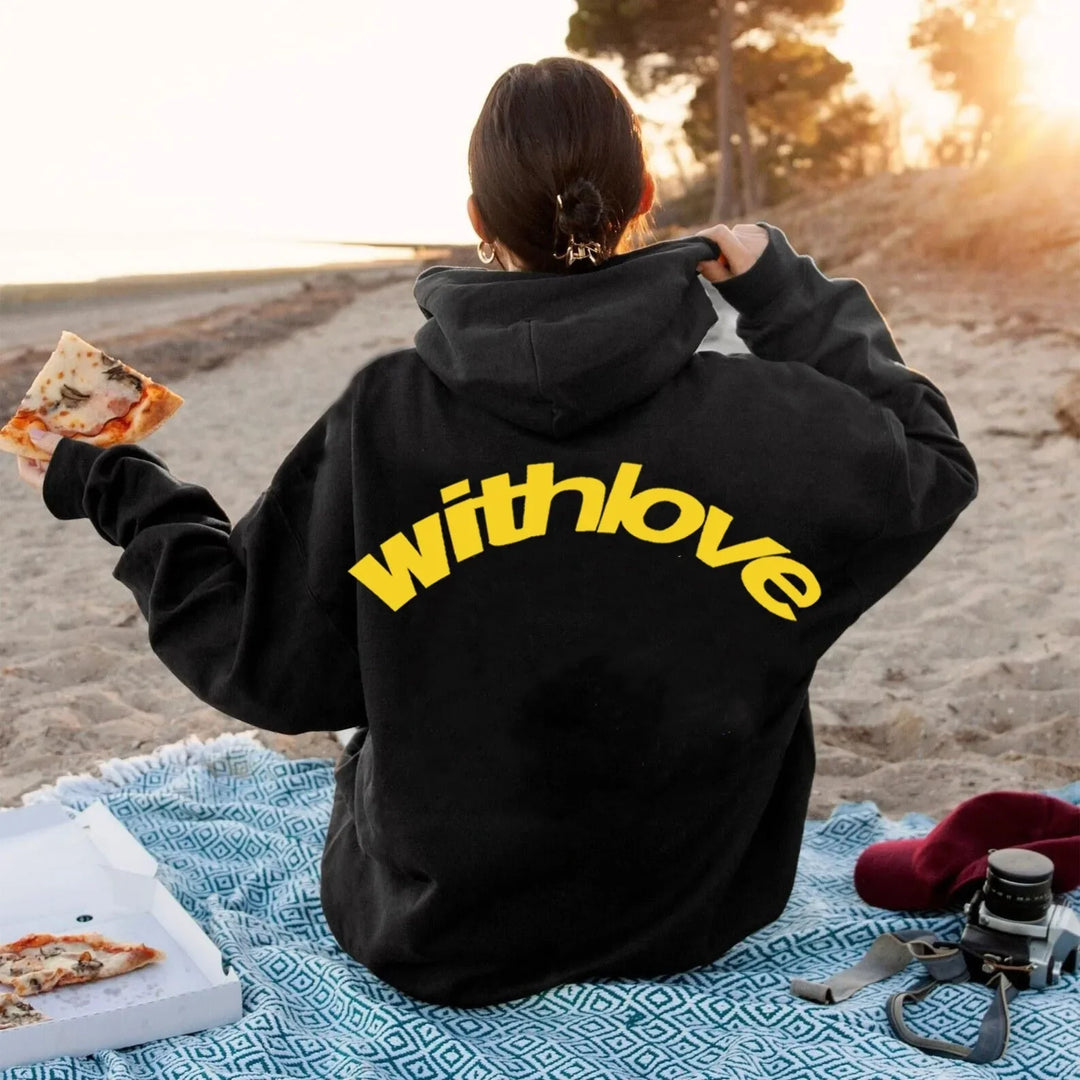 Woman wearing black withlove hoodie on beach
