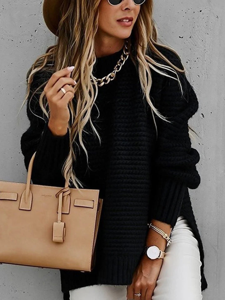 Woman wearing black chunky knit oversized sweater with side slit