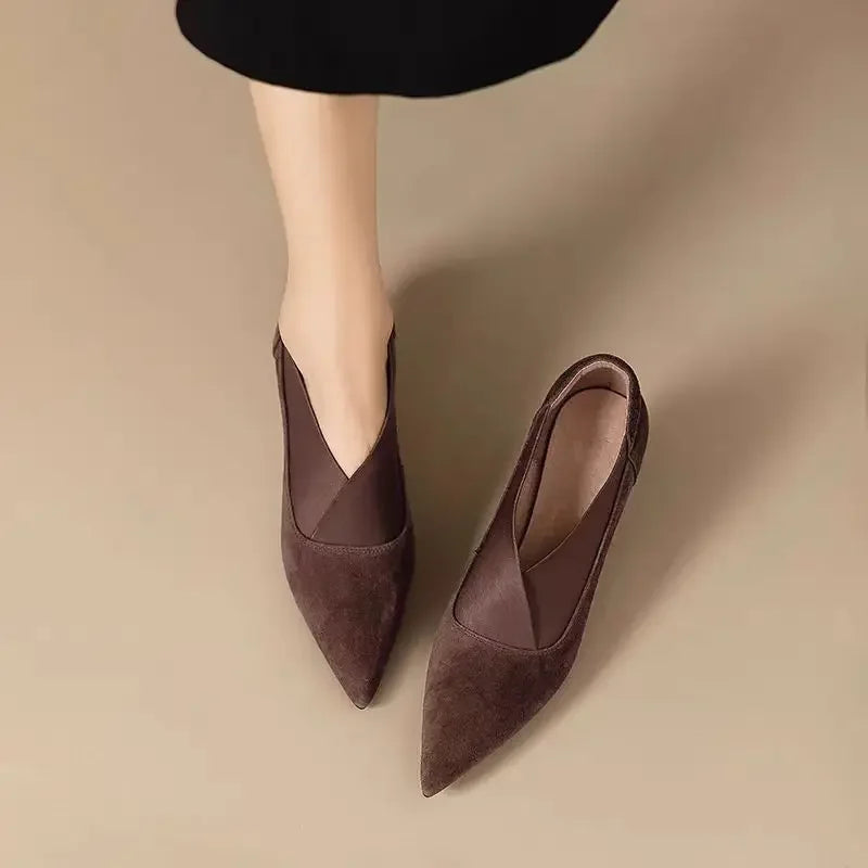 Dark brown suede pointed toe kitten heel pumps, top view on model