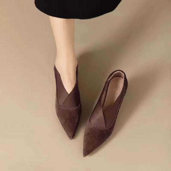 Dark brown suede pointed toe kitten heel pumps, top view on model