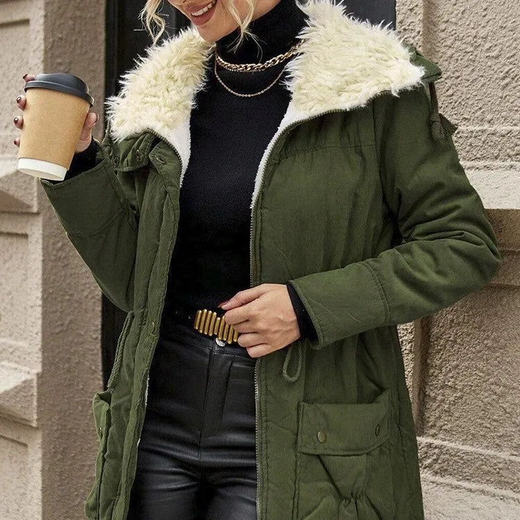 Close up of military green parka with drawstring waist and patch pockets