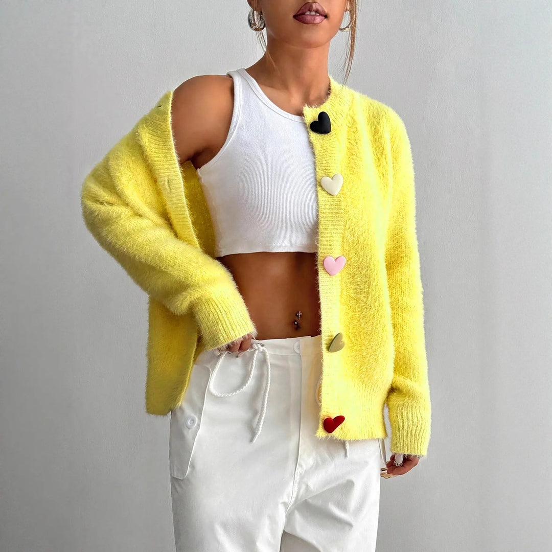 Woman wearing yellow fuzzy knit cardigan with heart buttons, front view