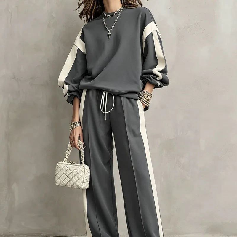 Woman wearing grey color block sweatshirt and wide leg pants set, close front view