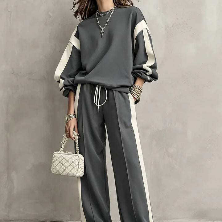 Woman wearing grey color block sweatshirt and wide leg pants set, close front view