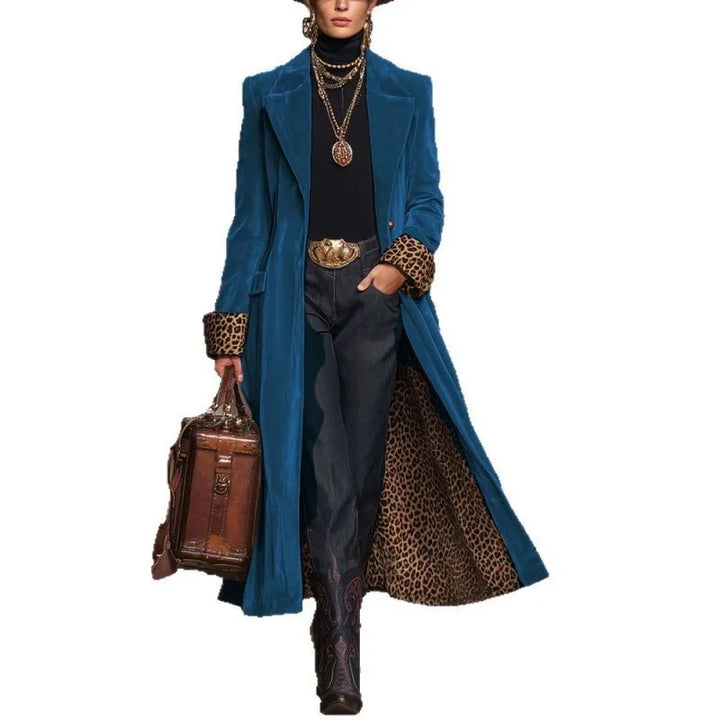 Woman in teal blue velvet trench coat with leopard cuffs, front view