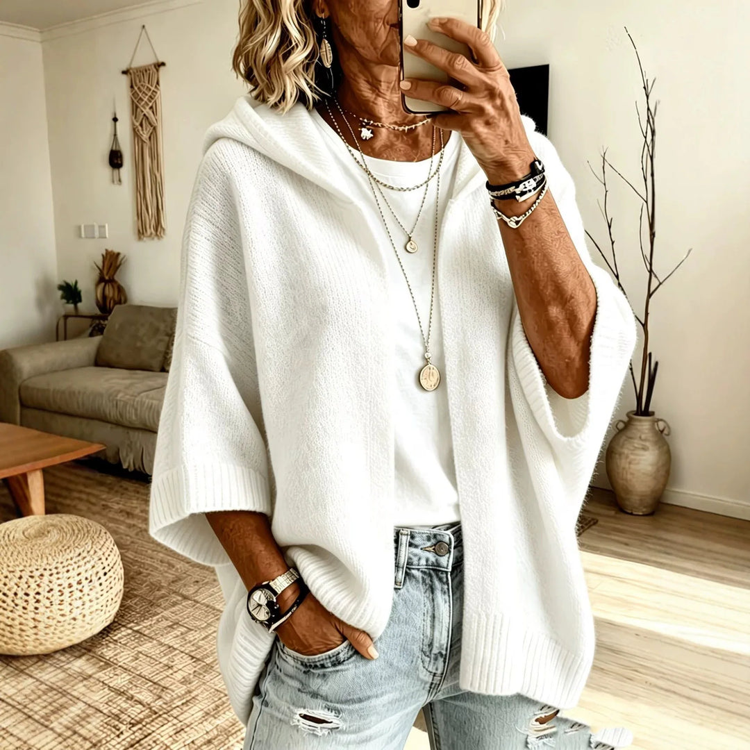 Woman wearing white hooded poncho cardigan with batwing sleeves