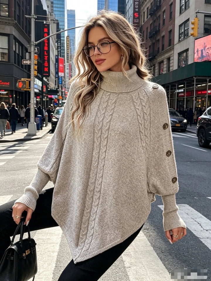 Woman wearing gray cable knit poncho sweater walking on city street
