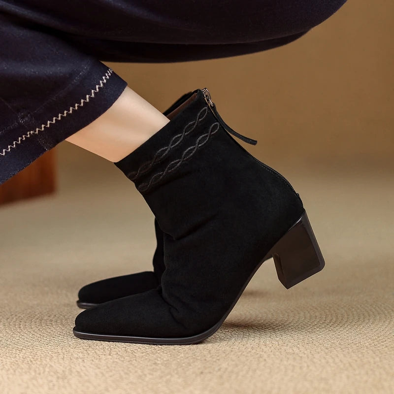 Side view of black suede ankle boot on model foot