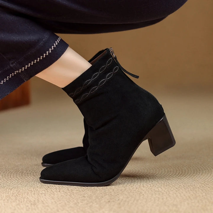 Side view of black suede ankle boot on model foot