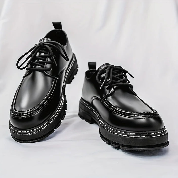 Black leather derby shoes with contrast stitching and lug sole, angled pair view