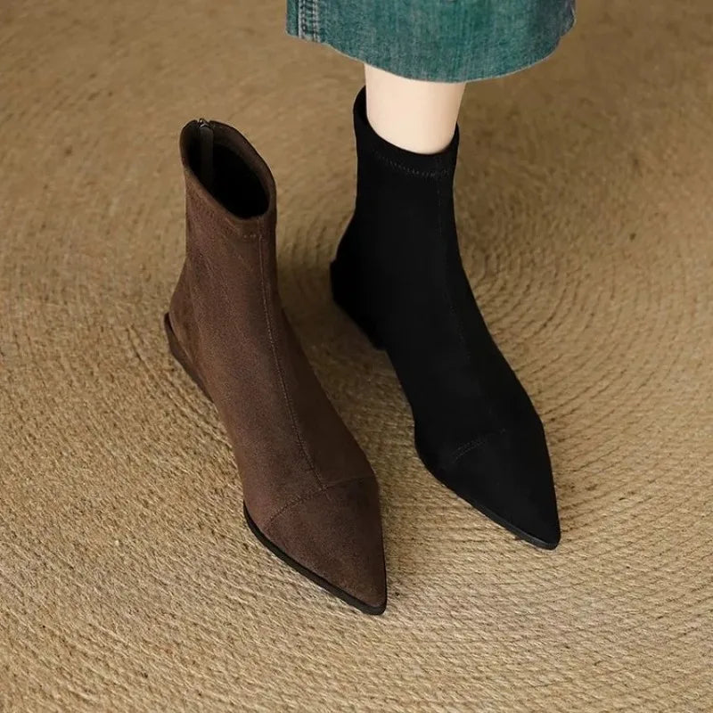 Brown and black suede ankle boots side by side on foot