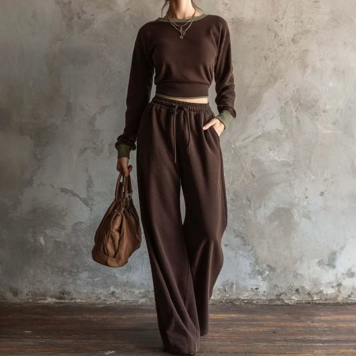 Woman wearing dark brown cropped sweatshirt and wide leg pants set with olive trim