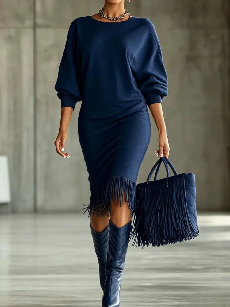 Woman wearing navy fringe hem sweater dress with fringe tote bag