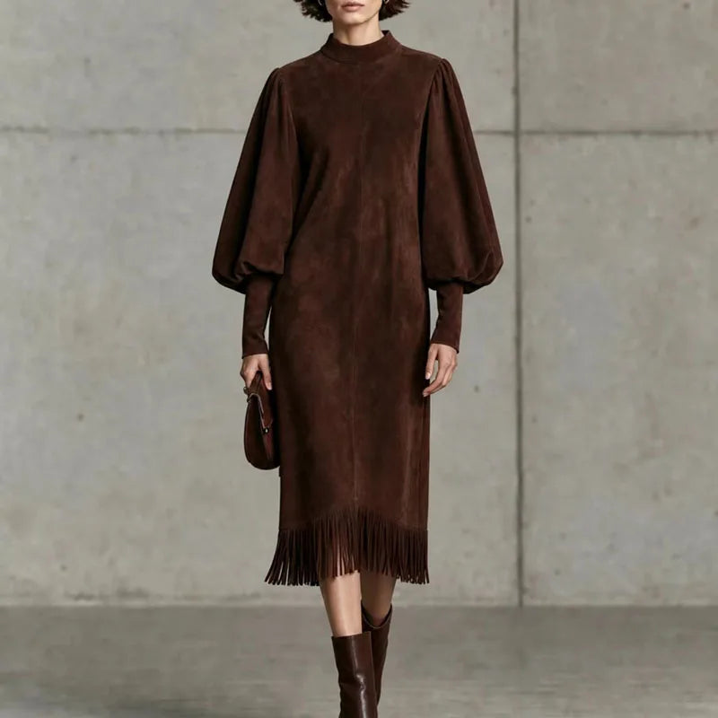 Woman wearing dark brown velvet lantern sleeve dress with fringe hem, front view