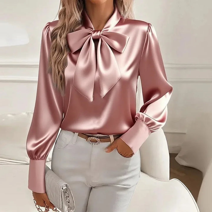 Woman wearing pink satin bow tie collar blouse