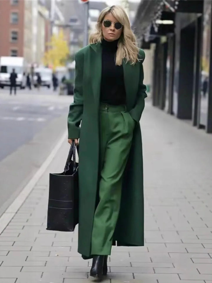 Woman wearing green long trench coat with matching green trousers