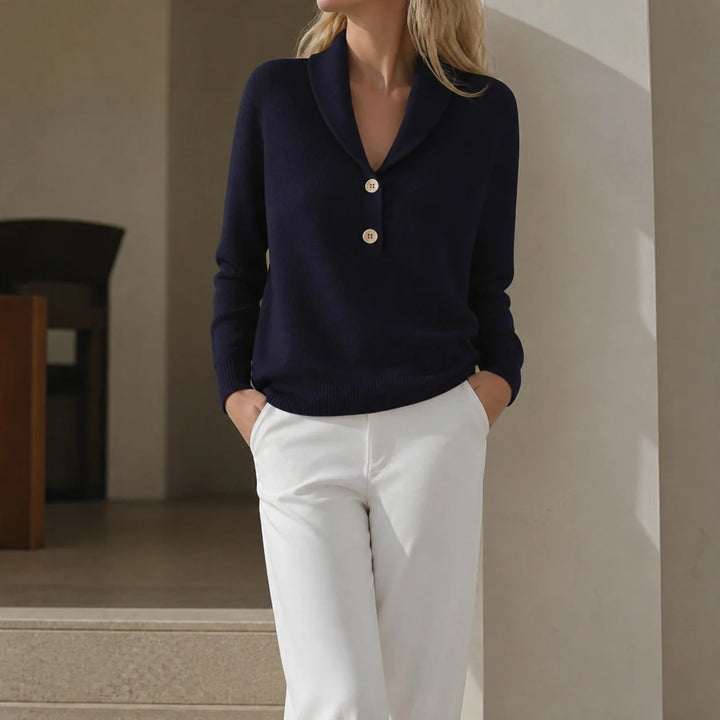Woman wearing navy blue shawl collar button sweater with white trousers