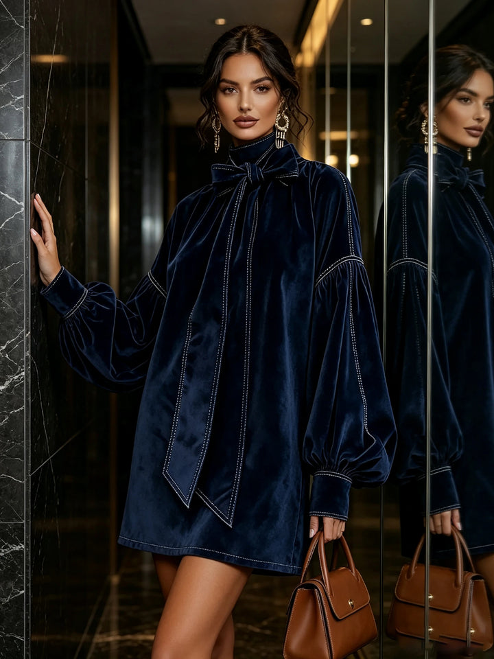 Navy velvet bow tie mini dress with lantern sleeves, standing pose