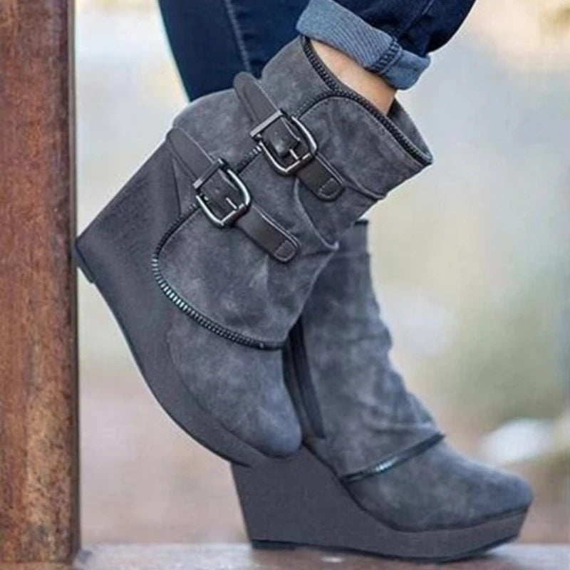 Model wearing gray suede wedge ankle boots outdoors