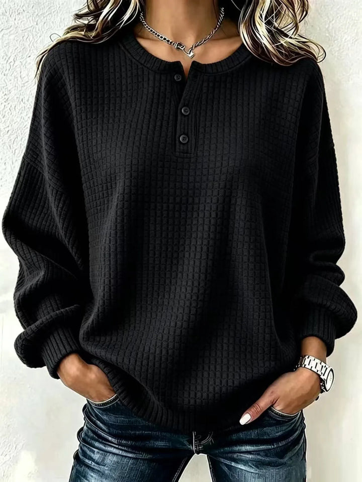 Woman wearing black waffle knit henley sweater