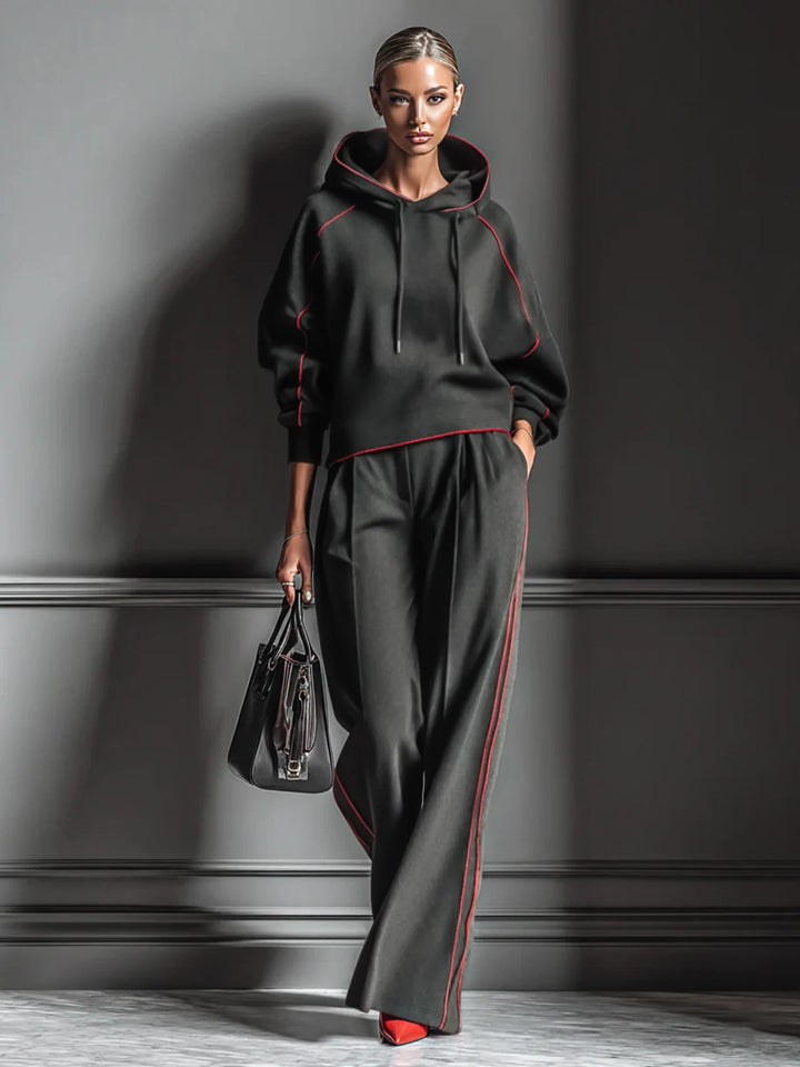 Close up front view of black hoodie and wide leg pants set with red piping