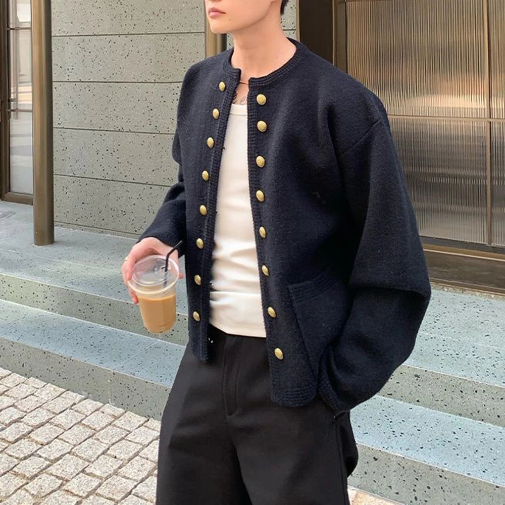 Man in black knit cardigan with gold buttons, front view