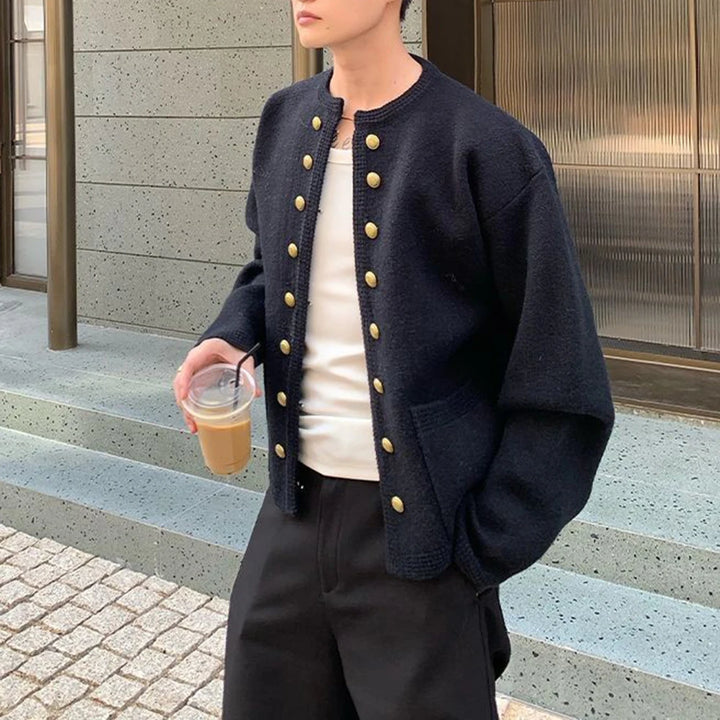 Man in black knit cardigan with gold buttons, front view