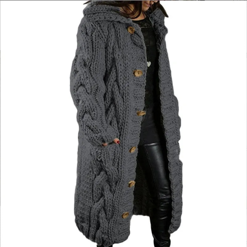Woman wearing light grey hooded cable knit long cardigan, side view