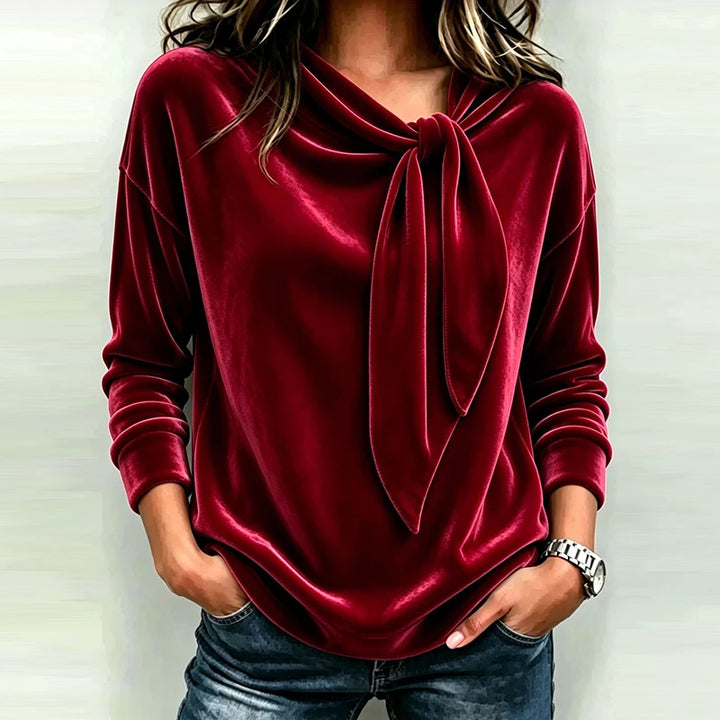 Woman wearing red velvet bow neck pullover top