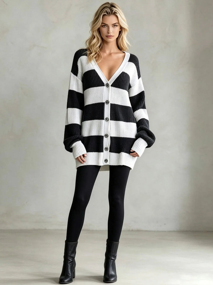 Woman wearing black and white striped oversized cardigan sweater with black boots