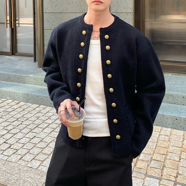 Man wearing black knit cardigan holding iced coffee, front view