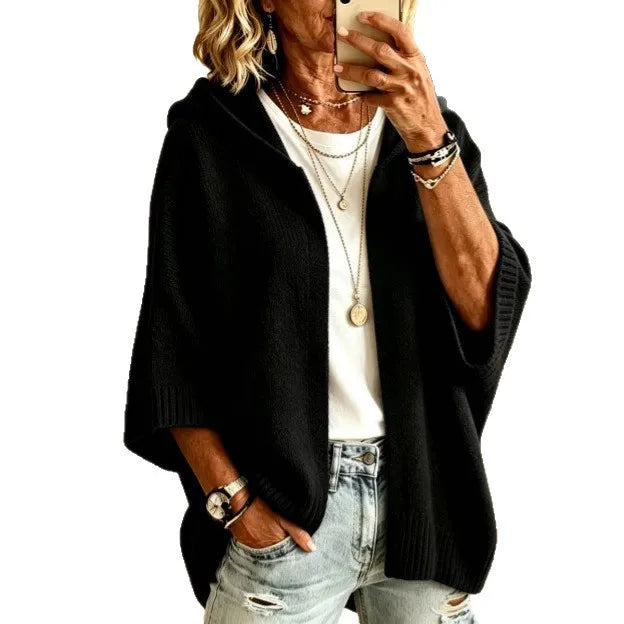 Woman wearing black hooded poncho cardigan with batwing sleeves