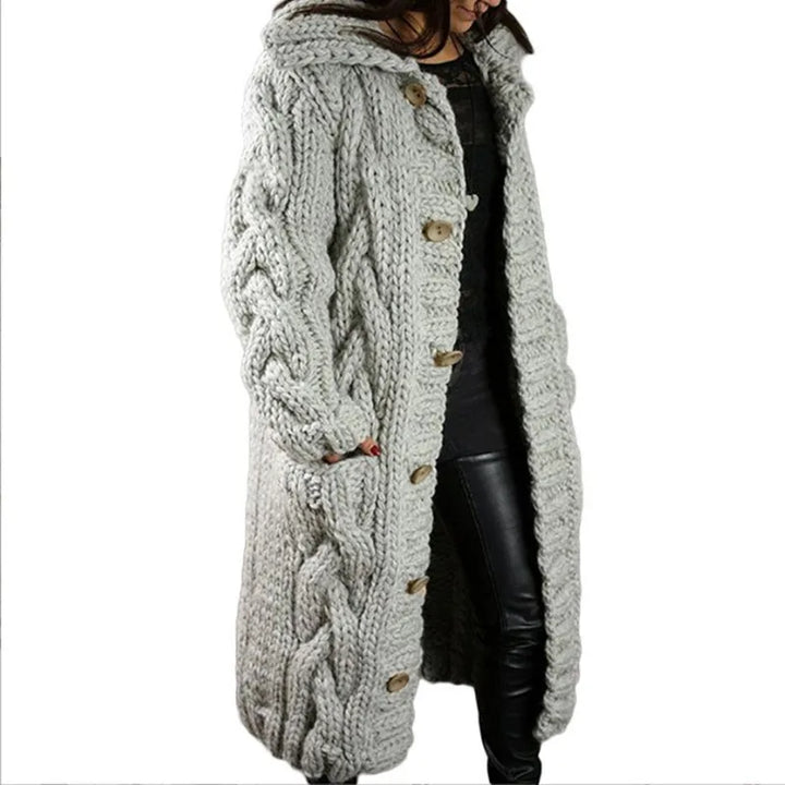 Woman wearing light grey hooded cable knit long cardigan, front angle