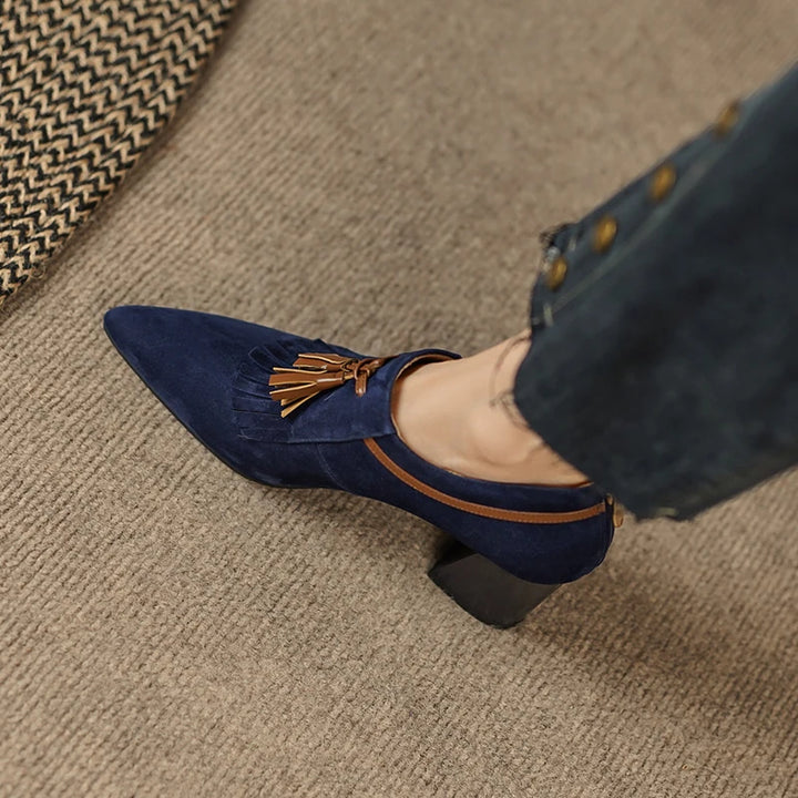 Overhead view of navy suede pump with tassel and piping detail