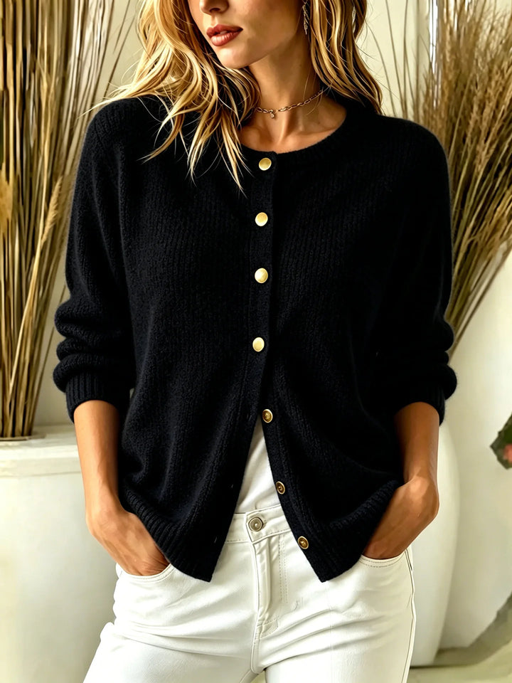 Close-up front view of black ribbed knit cardigan with gold buttons
