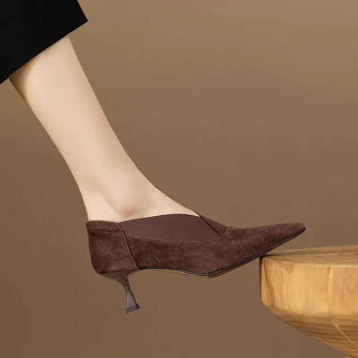 Side view of dark brown suede kitten heel pump on model's foot
