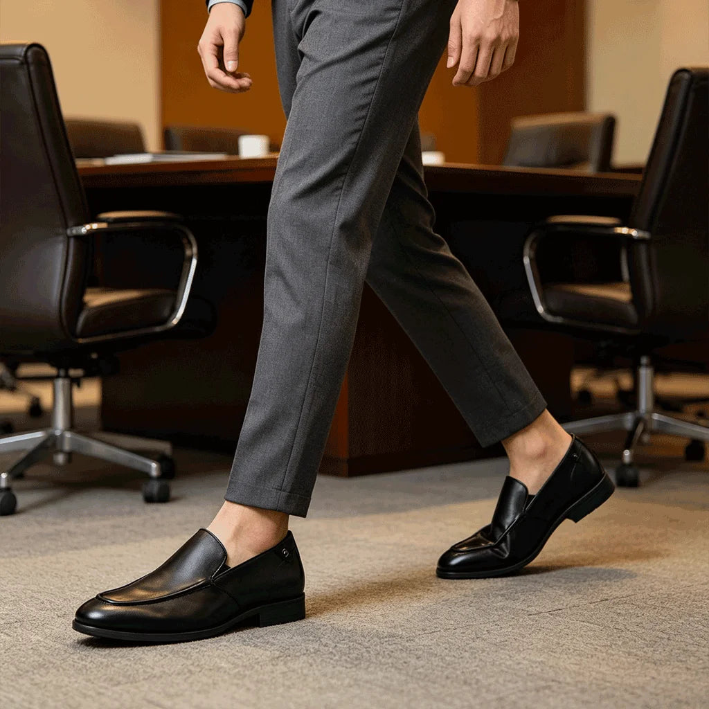 Man walking in black leather loafers in office setting