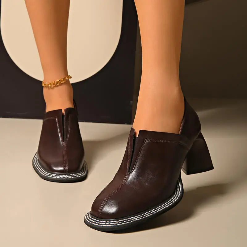 Woman wearing brown square toe loafers with block heel