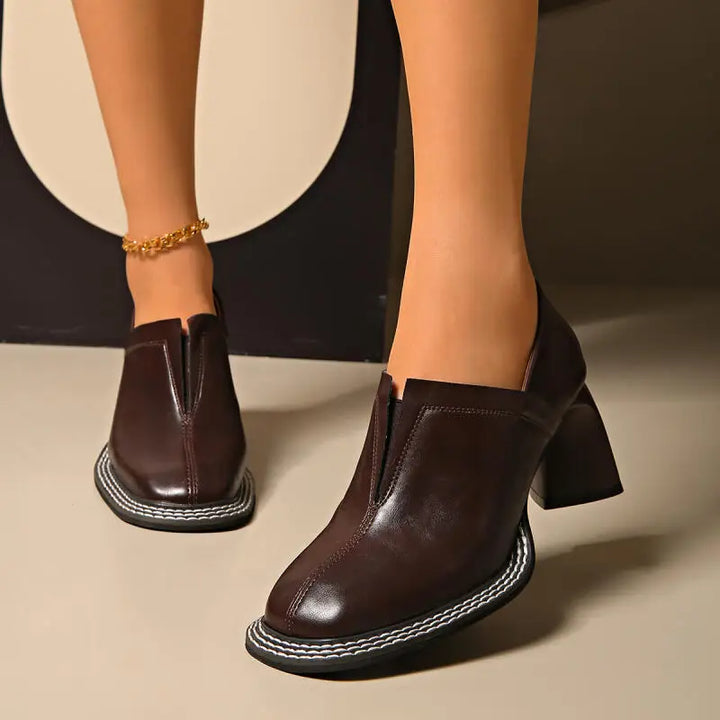 Woman wearing brown square toe loafers with block heel
