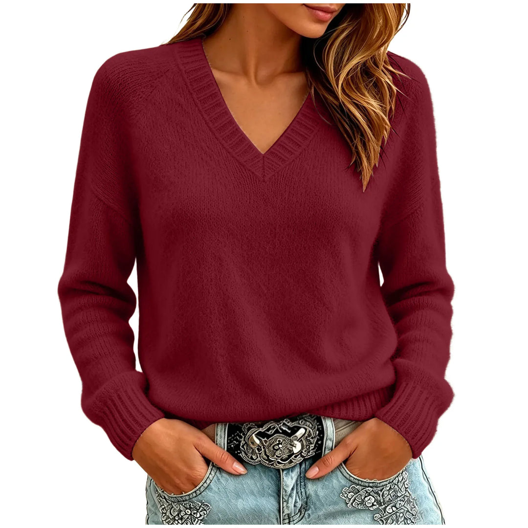 Woman wearing red oversized V-neck knit sweater with hands in pockets