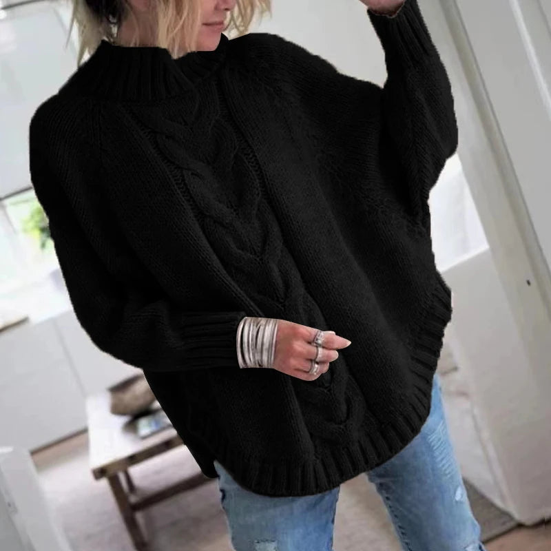 Woman wearing black cable knit oversized sweater, front view