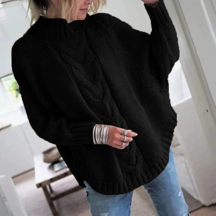 Woman wearing black cable knit oversized sweater, front view