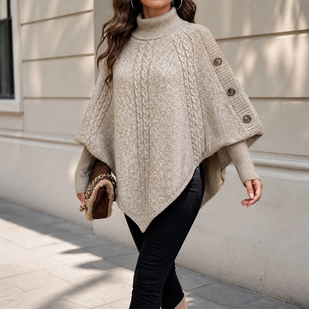Woman wearing khaki cable knit poncho sweater with turtleneck and button shoulder detail