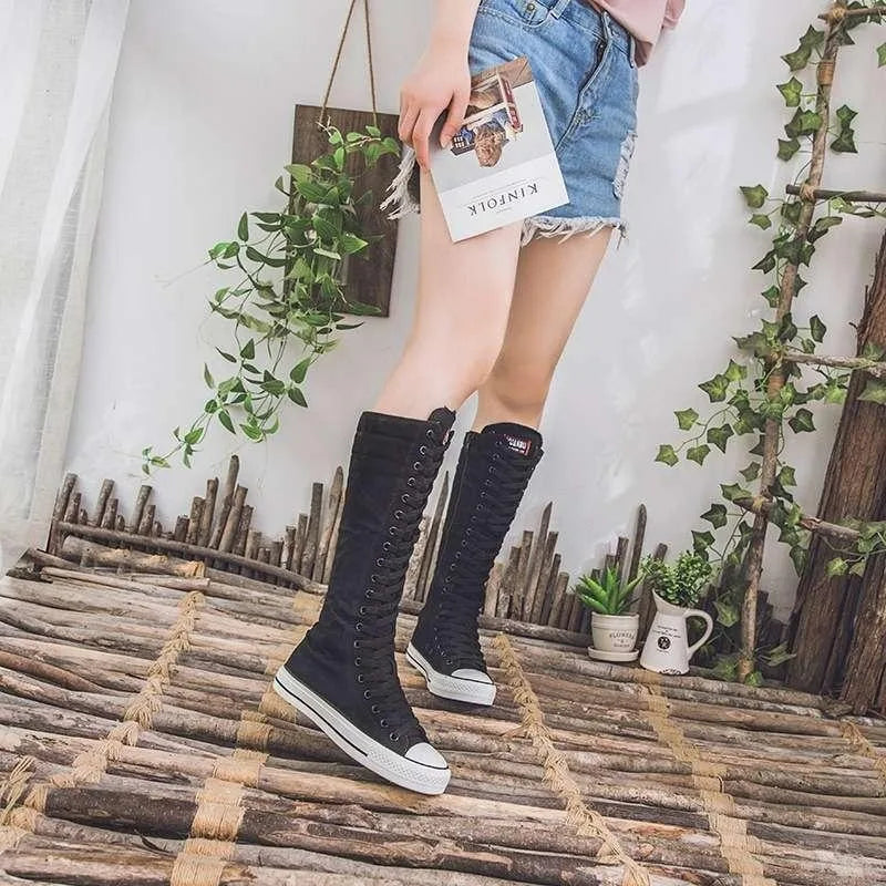 Model wearing black knee-high lace-up canvas boots outdoors