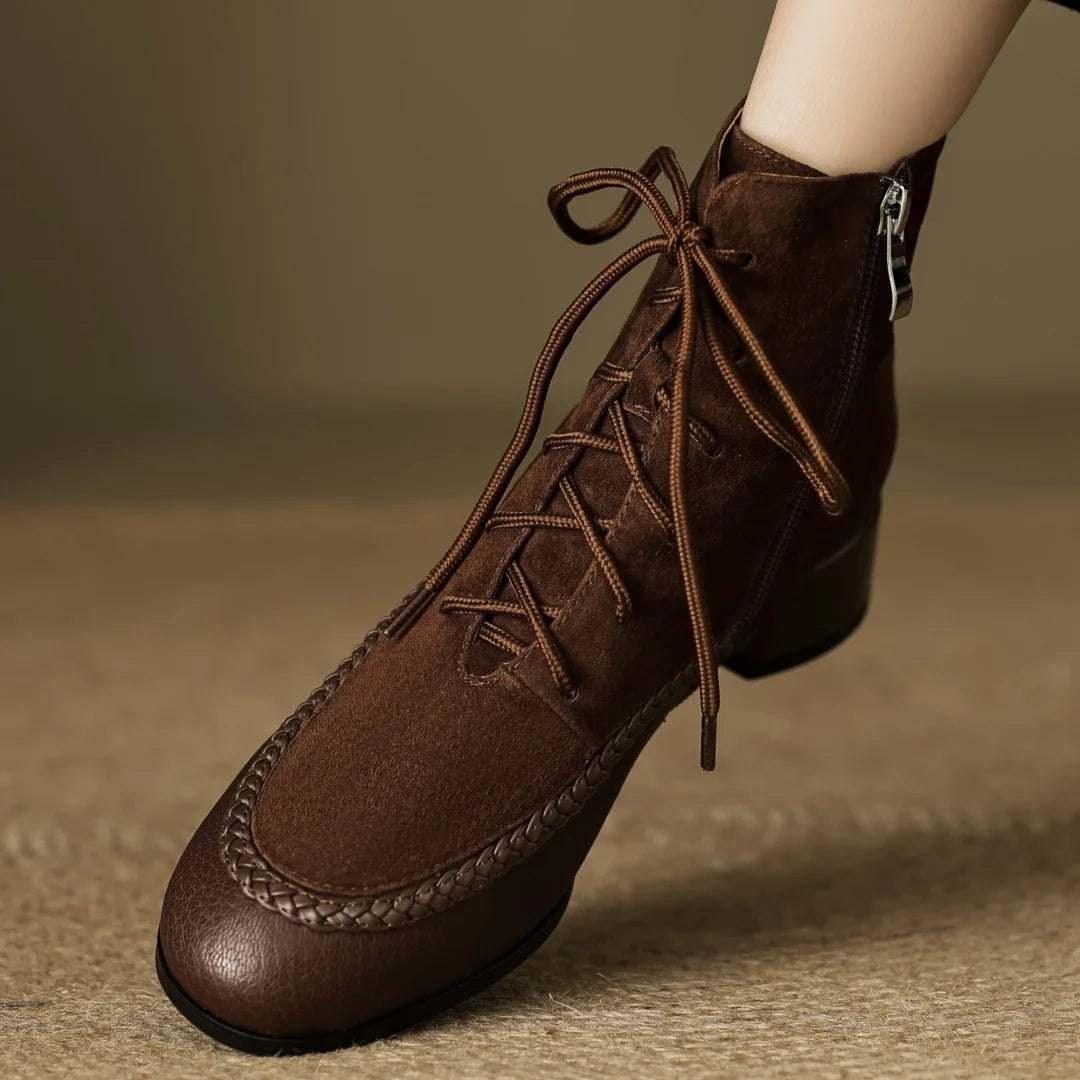 Brown suede ankle boot with braided leather toe detail on foot